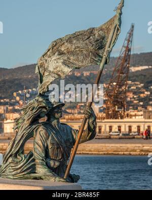 La statua di Bersagliere a trieste di fronte alla piazza dell'`unità. Bronzo di statua soldato di Bersagliere con bandiera a Trieste, vicino a unita d'Italia Foto Stock