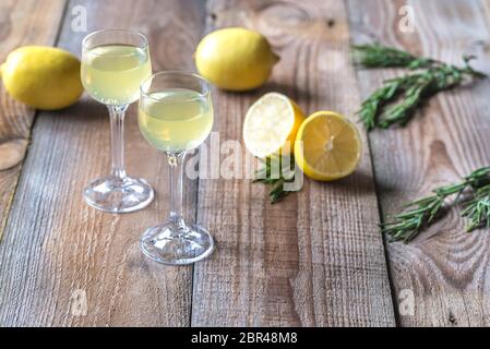 Bicchieri di limoncello sullo sfondo di legno Foto Stock