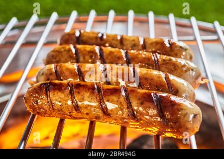 Delizioso e caldo salsicce alla griglia in close-up sulla griglia grill all'aperto Foto Stock