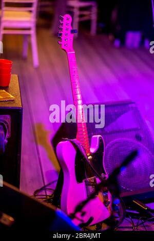 Chitarra elettrica e amplificatore audio in luce multicolore durante le feste sul palco. Vuoto di luce astratta stadio illuminato con chitarra elettrica un Foto Stock