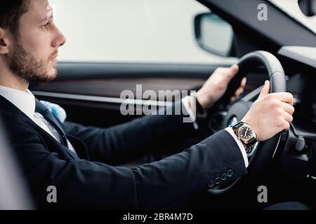 Giovane uomo d'affari che guida da solo in auto nuova Foto Stock