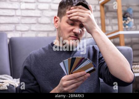 Ha sottolineato l'uomo Guardando troppo molte carte di credito in Home Foto Stock