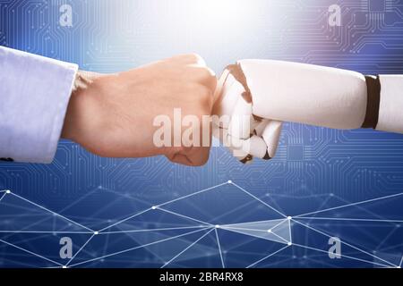 Il robot e la mano umana facendo Fist Bump blu su sfondo digitale Foto Stock