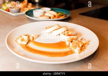Condire i pancake al formaggio con salsa al caramello e banane Foto Stock