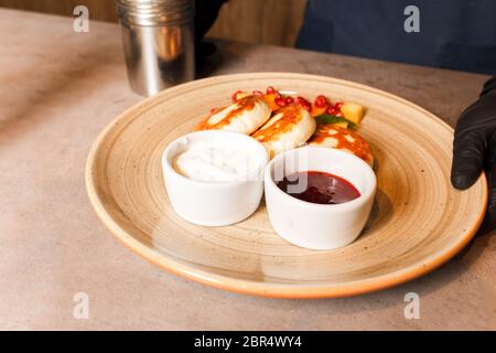 Frittelle di formaggio con marmellata di lamponi sul piatto. Cheesecake con marmellata. Colazione sana e gustosa. Foto Stock