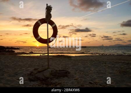 Tramonto dalla spiaggia di Espalmador Pass con un salvavita sospeso (Parco Naturale di Ses Salines, Formentera, Pityuses, Isole Baleari, Mar Mediterraneo, Spagna) Foto Stock