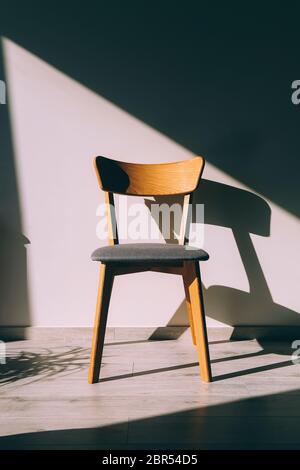 Lo sgabello e l'ombra sul pavimento in parquet Foto Stock