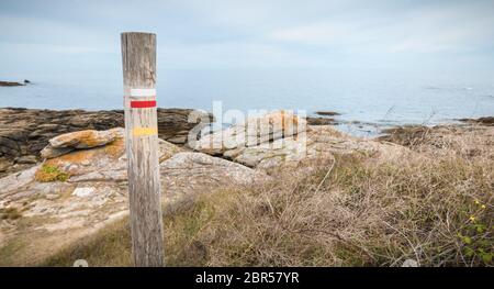 Log in legno che indica un lungo percorso a piedi dal mare sull'isola di Yeu, Francia Foto Stock