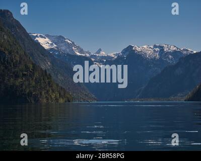 Vista sulle montagne coperte di neve e la chiesa St. Bartholomä presso il Königssee a Berchtesgaden Foto Stock