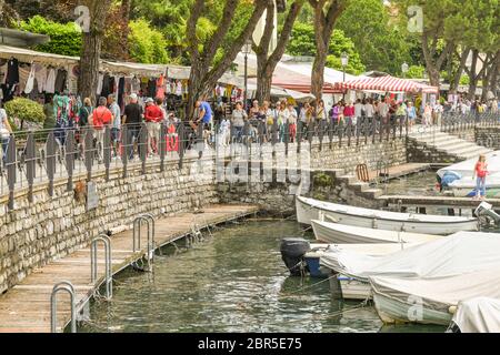 LENNO, LAGO DI COMO, ITALIA - 2019 GIUGNO: Le persone che camminano davanti alle bancarelle del mercato sul lungolago di Lenno sul Lago di Como. Foto Stock