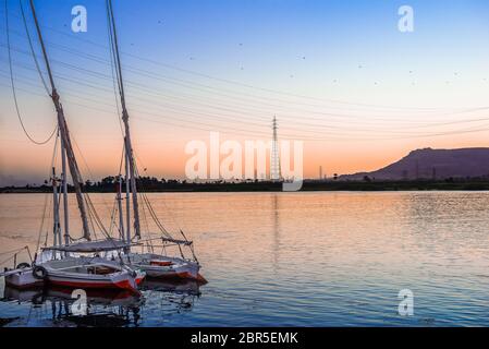Barche a vela ormeggiata sul fiume Nilo a Luxor al tramonto Foto Stock