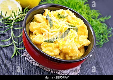 Gnocchi di zucca con salvia, limone, il formaggio e il burro in una ciotola, tela, forcella sulla tavola di legno sfondo Foto Stock