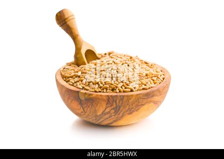 Una sana chicchi di farro in ciotola di legno isolato su sfondo bianco. Foto Stock