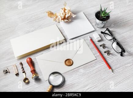 Foto di blank vintage stationery in luce sullo sfondo di legno. Foto Stock