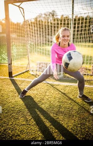 Femmina Teen goalie cattura un colpo durante una partita di calcio Foto Stock