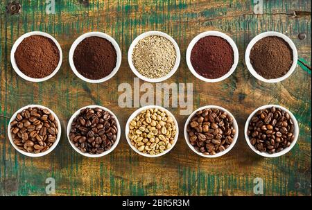 Pulite sempre la vita di un assortimento di varietà di caffè macinato e medie, pieno e dolce di fagioli arrosto in singoli recipienti su un legno rustico sfondo visualizzato Foto Stock