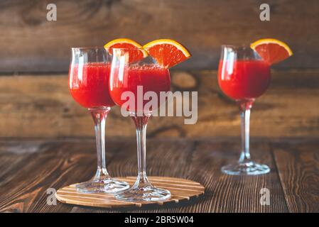 Tre Bicchieri di Mimosa cocktail sullo sfondo di legno Foto Stock