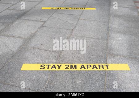 Cartello con la sigla "Stay Apart 2 m" sul pavimento - Regno Unito Foto Stock