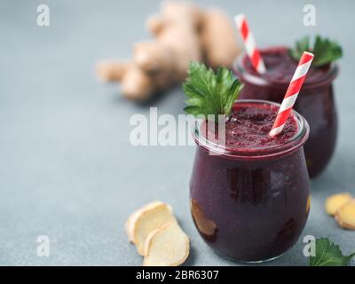 La barbabietola rossa fresca e radice di zenzero frullato. Frullato di barbabietole in un barattolo di vetro sulla tabella grigia. DOF poco profondo. Copia spazio per il testo. Pulire e mangiare concep detox Foto Stock