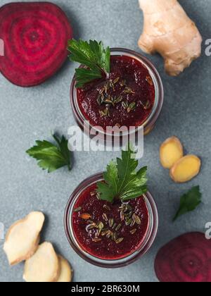 La barbabietola rossa fresca e radice di zenzero frullato. Frullato di barbabietole in un barattolo di vetro sulla tabella grigia. DOF poco profondo. Copia spazio per il testo. Pulire e mangiare concep detox Foto Stock