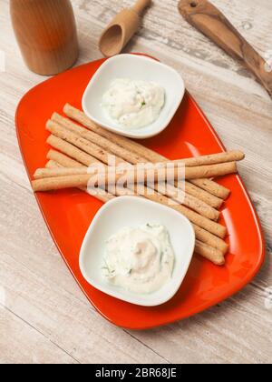 Fresche biologiche di crema di formaggio con erba cipollina e prezzemolo e servite con il farro biologico bastoni Foto Stock