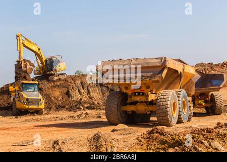 Costruzioni industriali earthworks macchina livellatrice caricamento della terra in grandi autocarri Foto Stock