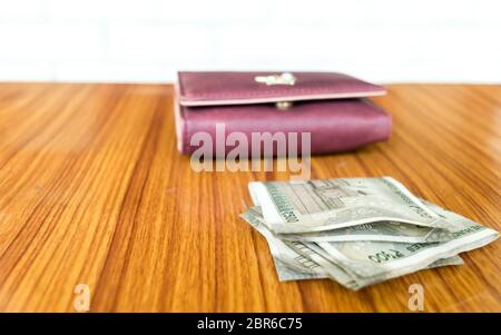 Indian cinquecento (500) rupee contanti nota di colore marrone portafoglio portafoglio in pelle su di un tavolo di legno. Finanza aziendale il concetto di economia. Lato Vista angelo wit Foto Stock