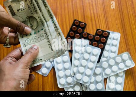 Il cliente offre del denaro per comprare il farmaco alla farmacia farmacia. Vista ravvicinata. Varie capsule, compresse, pillole in medicina shop su sfondo tabella. Pharmac Foto Stock