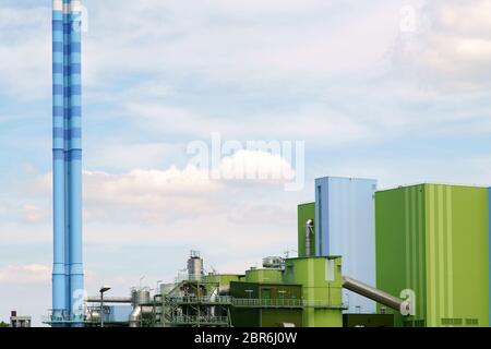 Il colorfully dipinto camino così come edifici industriali di un impianto di alimentazione. Foto Stock