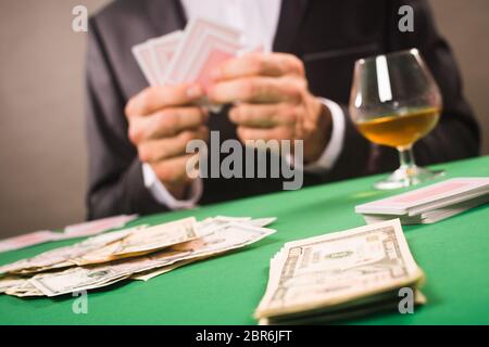 Il giocatore sta giocando a poker o altro gioco con carta da gioco per soldi, idea di gioco. Foto Stock