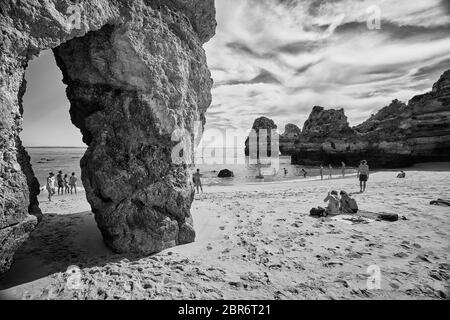 La gente si rilassa sulle spiagge di Lagos, Portogallo, dove spettacolari formazioni rocciose di arenaria si erigono dalle acque del Mar Mediterraneo Foto Stock