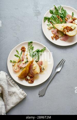 Insalata di pere con noci, prosciutto, rucola e formaggio blu. Antipasto per cena Foto Stock