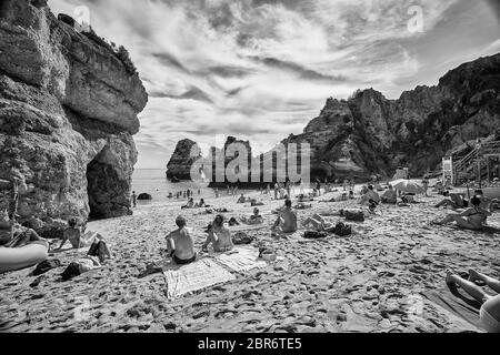 La gente si rilassa sulle spiagge di Lagos, Portogallo, dove spettacolari formazioni rocciose di arenaria si erigono dalle acque del Mar Mediterraneo Foto Stock