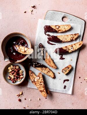 Biscotti alla nocciola immersi in una ciotola di cioccolato fuso. Foto Stock