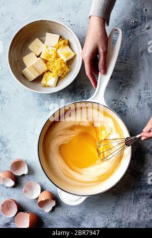 Miscela di limoni mescolati in una pentola con una frusta a mano. Foto Stock