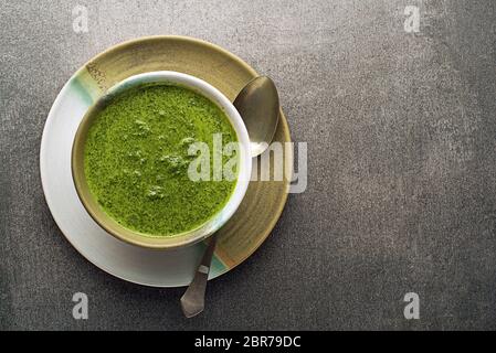 La molla di alimenti sani. Verde zuppa cremosa con le verdure e le erbe su sfondo grigio Foto Stock