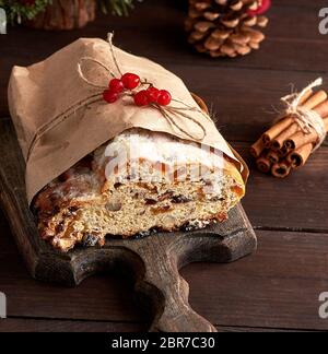 Affettare tradizionale torta europea lo Stollen con dadi e frutta candita spolverato di zucchero a velo Foto Stock