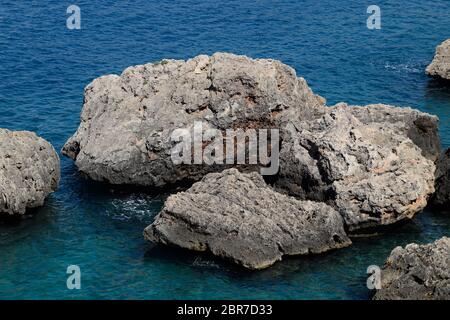 Scogliere calcaree dal mare. Battito delle onde sugli scogli. Foto Stock