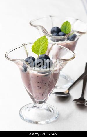 Bacche blu yogurt su bianco Foto Stock