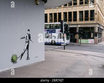 Un nuovo murale dell'artista di strada 'l'orso ribelle' che mostra un uomo incatenato a una molecola di virus, in strade vuote nel centro di Glasgow, evidenziando le linee guida di allontanamento sociale e gli avvisi 'a casa' dovrebbero essere rispettati durante il blocco pandemico di Coronavirus. Foto Stock