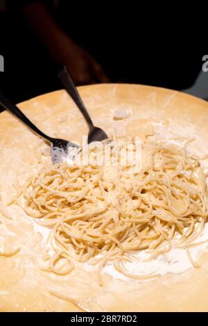 Lo chef cucinare la pasta nella ciotola di formaggio Foto Stock