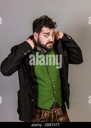 Cool man con il costume tradizionale è in posa di fronte a uno sfondo grigio Foto Stock