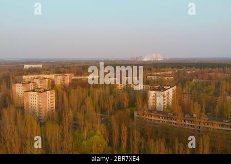 Paesaggio vista superiore della centrale nucleare di Chernobyl si apre. Viste della città di pripjat vicino alla centrale nucleare di Cernobyl al tramonto, aeria Foto Stock