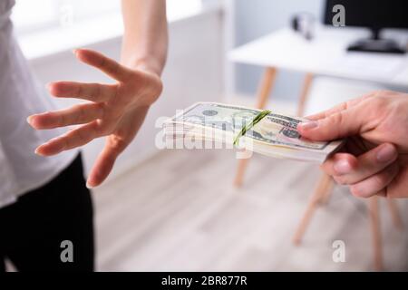 Close-up donna la mano rifiutando di prendere tangenti da uomo Foto Stock