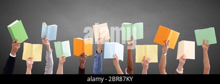 Vista panoramica di persone la mano che tiene libri colorati in grigio sullo sfondo Foto Stock