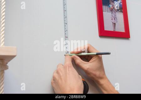 Mani segnare sulla parete la disposizione di fotogrammi con le foto Foto Stock