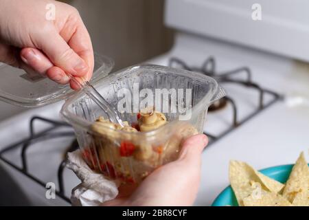 Aggiunta di antipasti a fungo di corn chips per rendere nachos Foto Stock