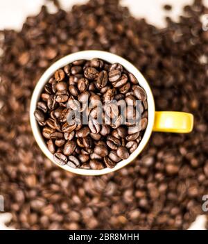 Fagioli di caffè tostati marroni, semi su sfondo scuro. Espresso scuro, aroma, caffeina nera. Closeup energia isolata mocha, cappuccino ingrediente. Foto Stock