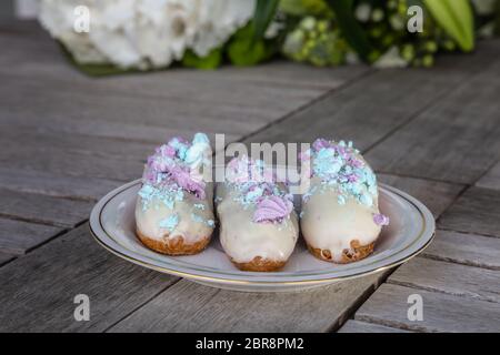 In stile tradizionale francese eclairs tipicamente viene convogliata in una forma oblunga con una sacca di tela da pasticceria Foto Stock