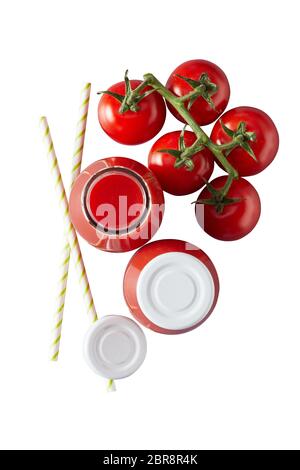 Due vasi di vetro con coperchi di colore bianco pieno di rosso succo di pomodoro accanto a pomodori ciliegia sulla vite e due cannucce Foto Stock